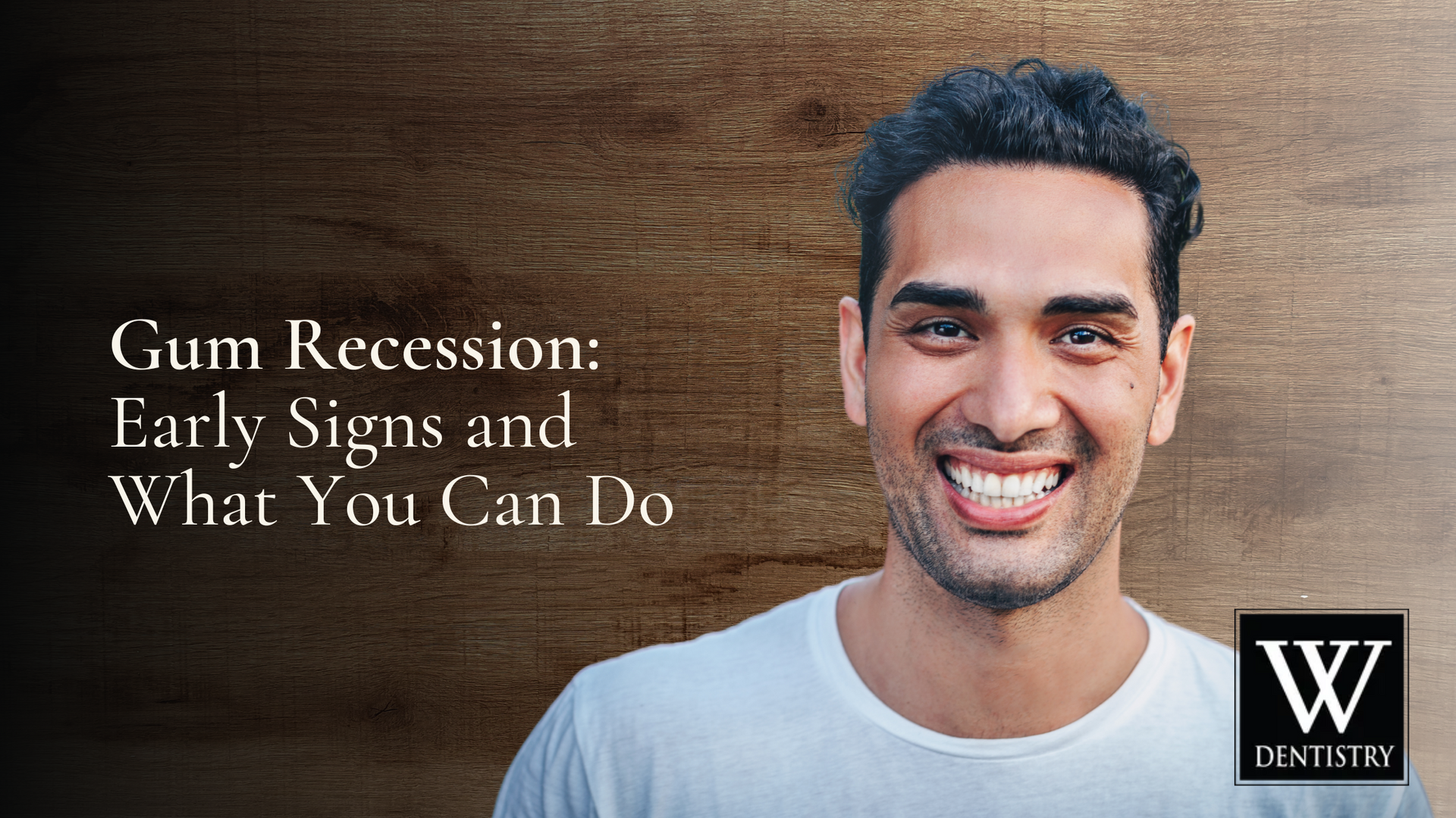 A man is smiling in front of a wooden background.