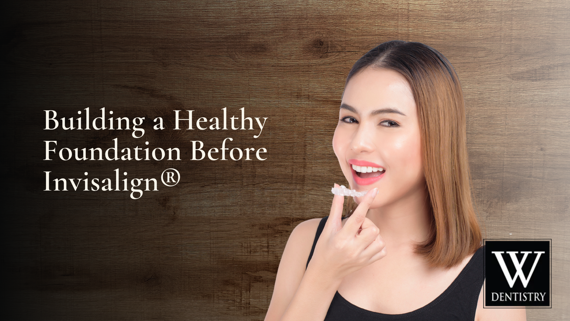 Woman holding Invisalign aligner, smiling, in front of wood-grain background. Text: