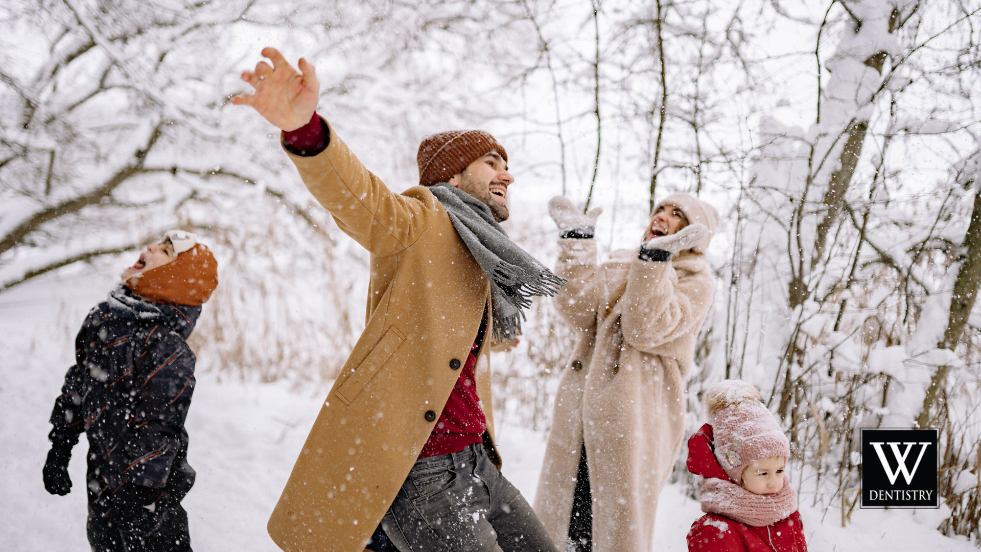 A family is playing in the snow together.