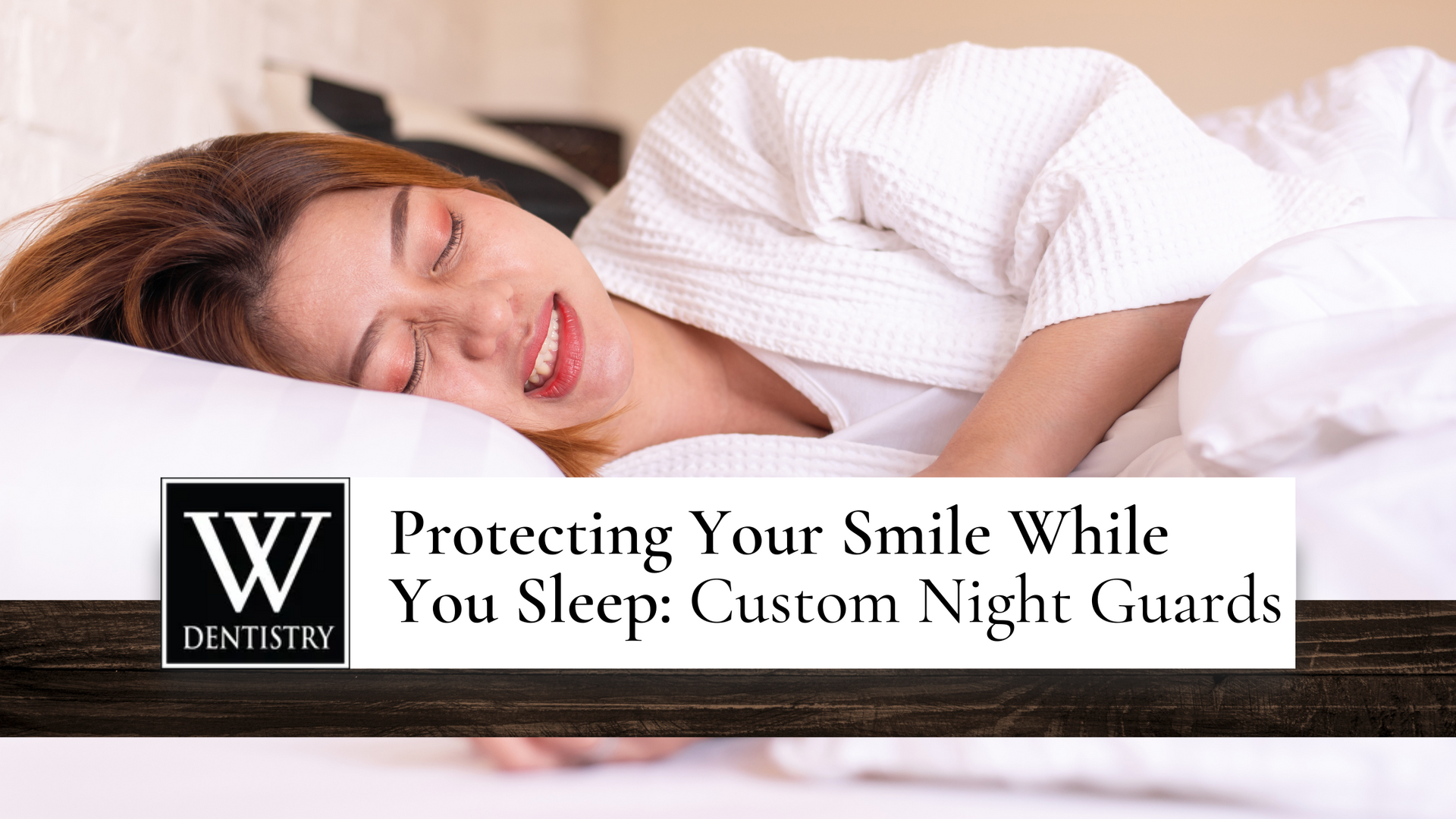 A woman is smiling while sleeping in a bed.