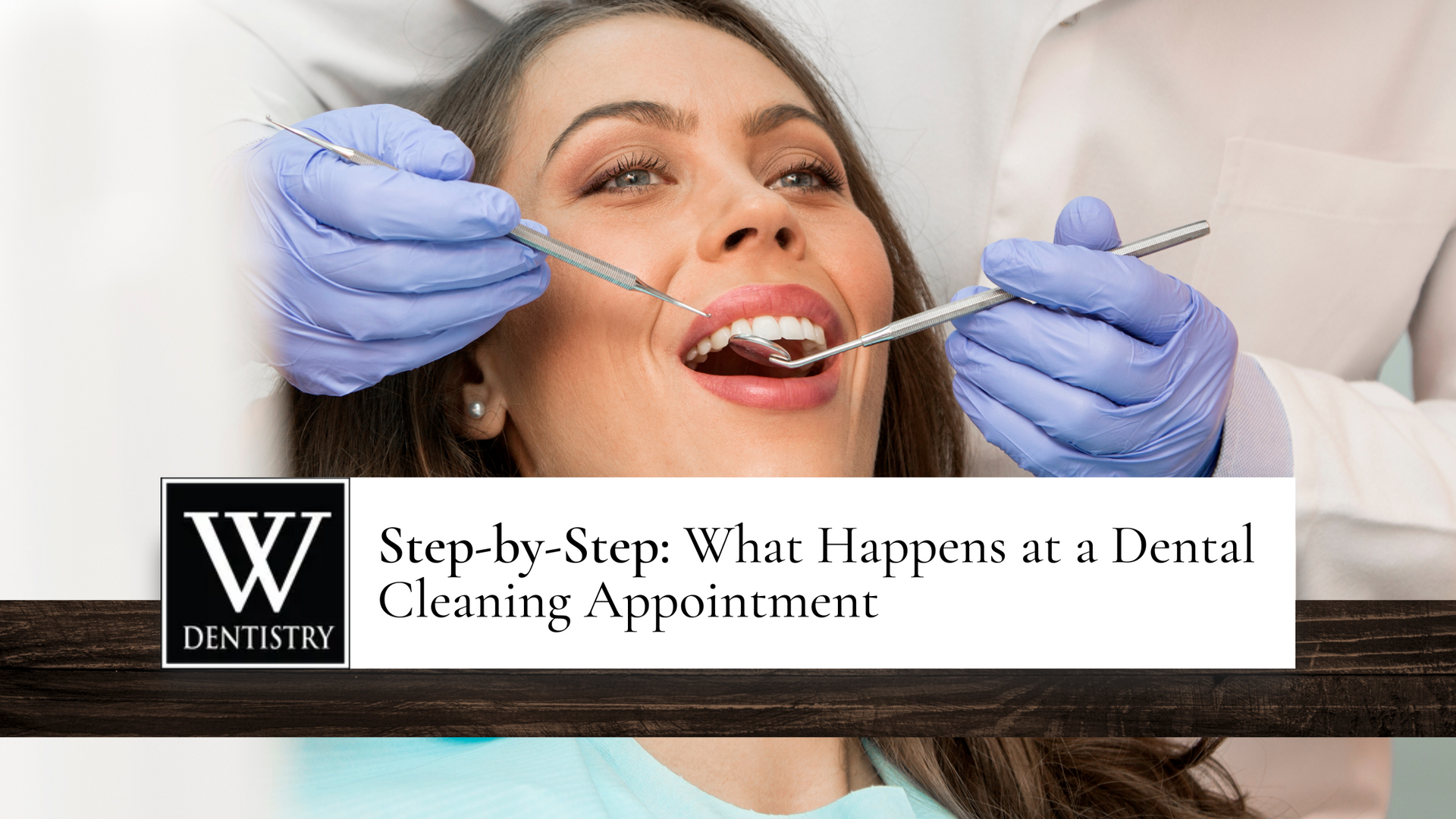 Woman at dental cleaning appointment, being examined by dentist.