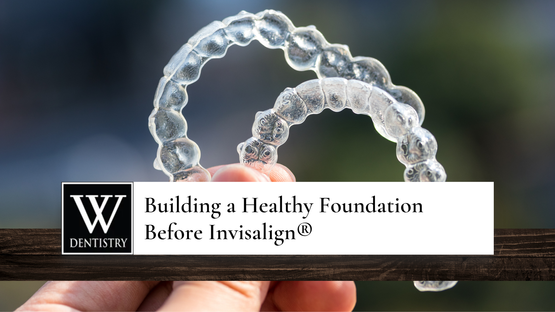 Hand holding clear Invisalign aligners, text 