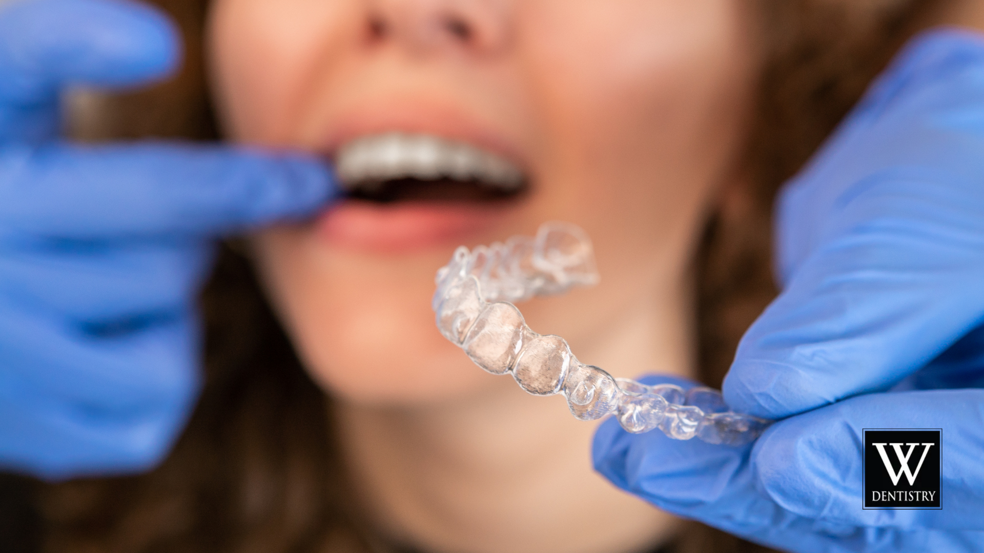 A woman is getting her teeth straightened by a dentist.