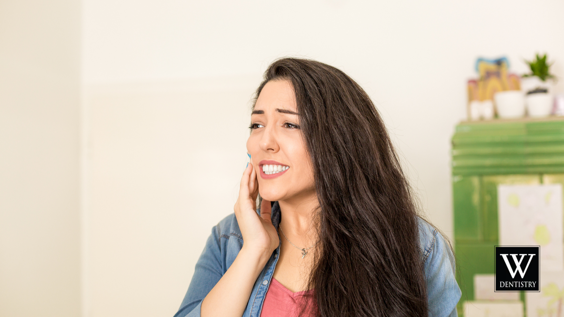 A woman is holding her face in pain because she has a toothache.