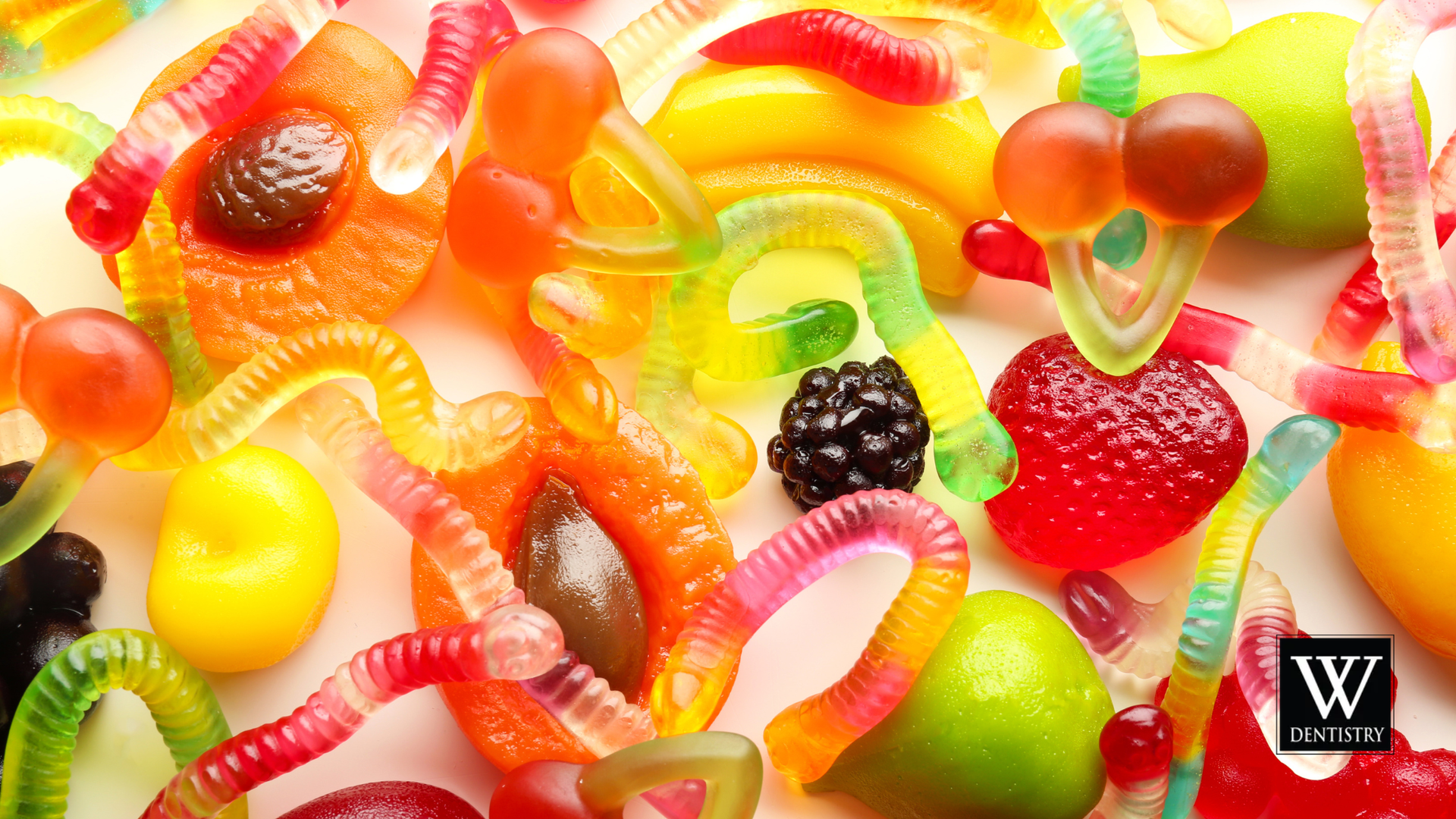 Assorted colorful gummy candies, including worms, fruits, and other shapes, close-up.