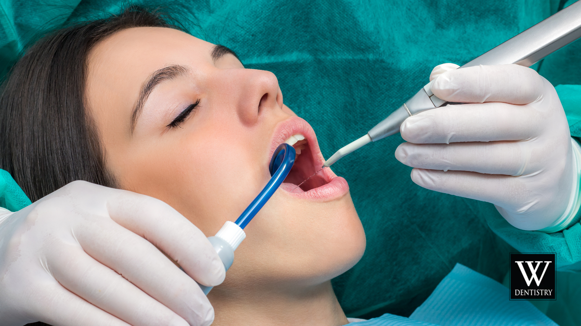 A woman is getting her teeth examined by a dentist.