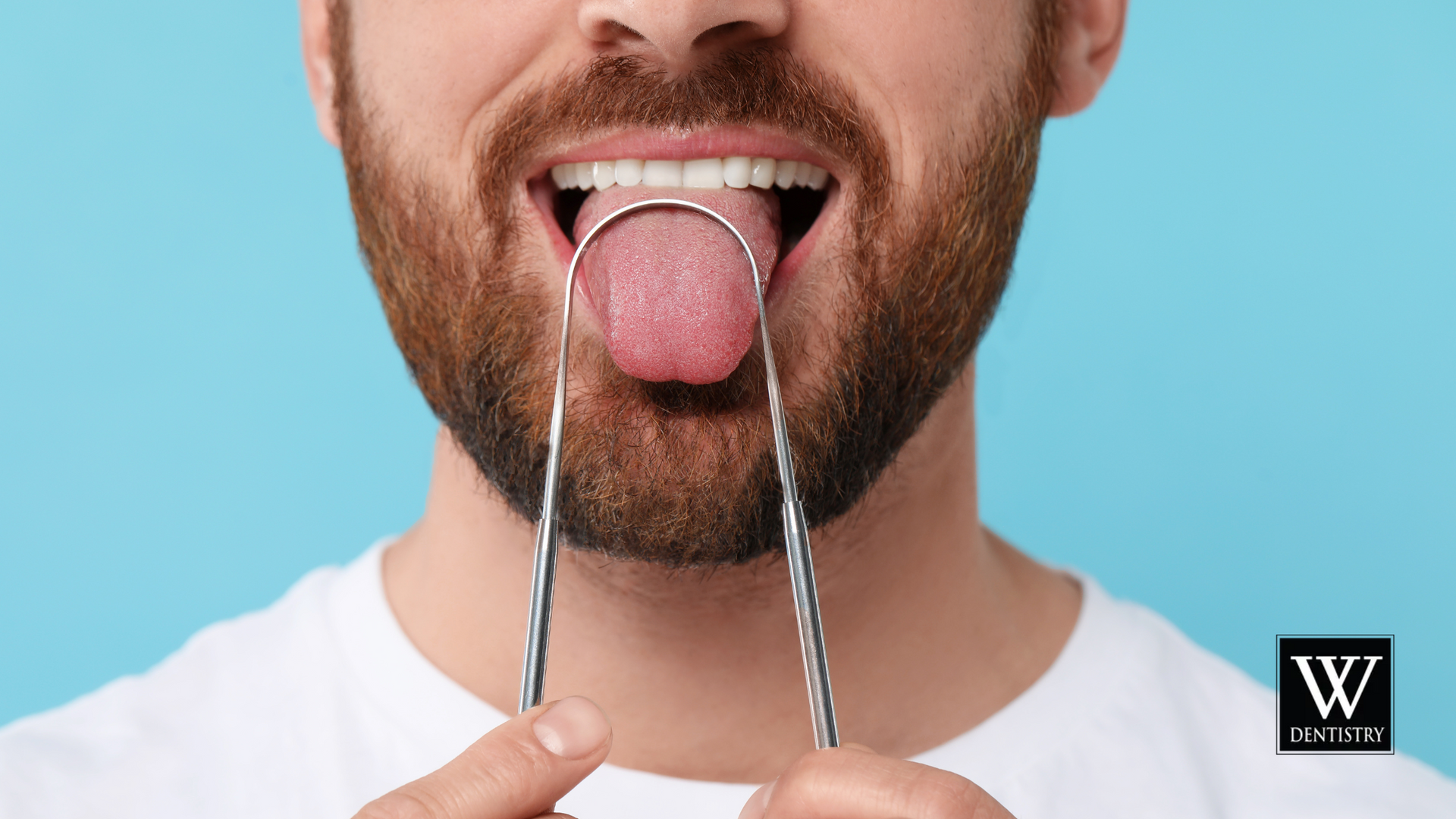 A man is cleaning his tongue with a tongue scraper.