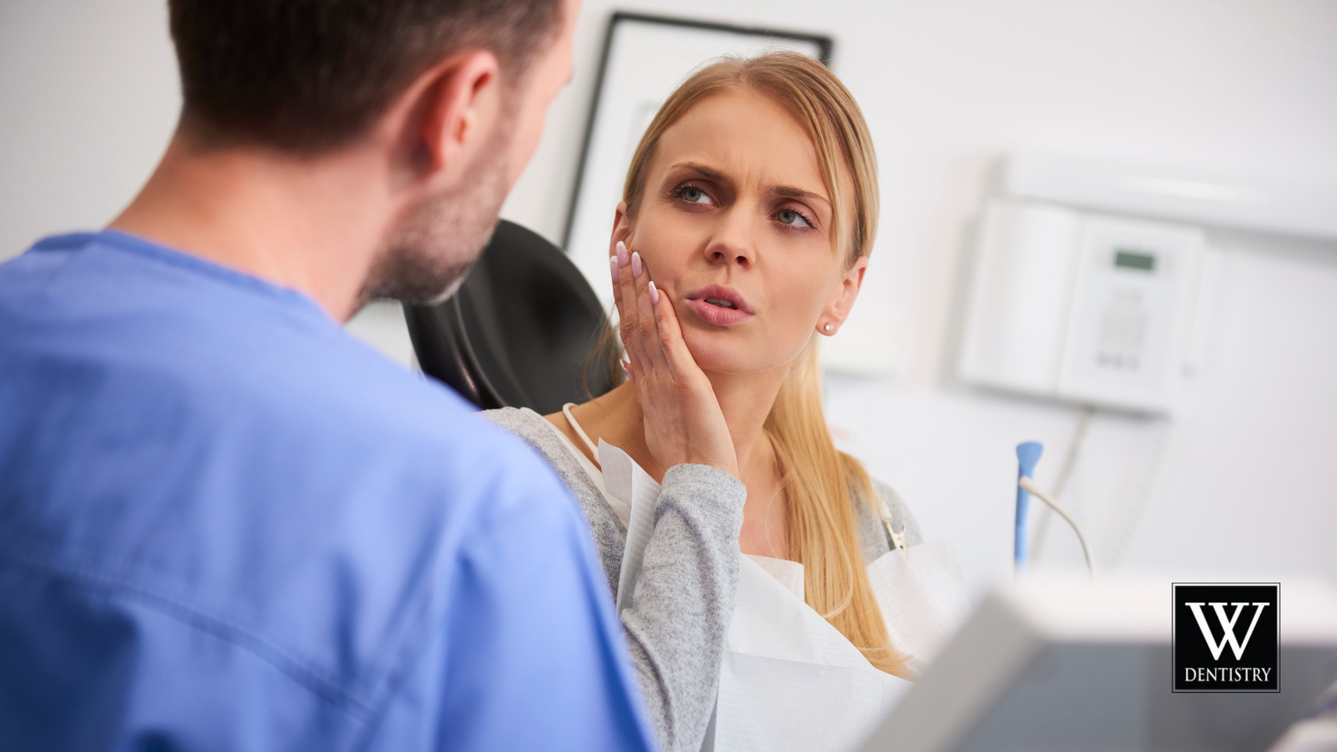 A man and a woman are talking to each other in a dental office.