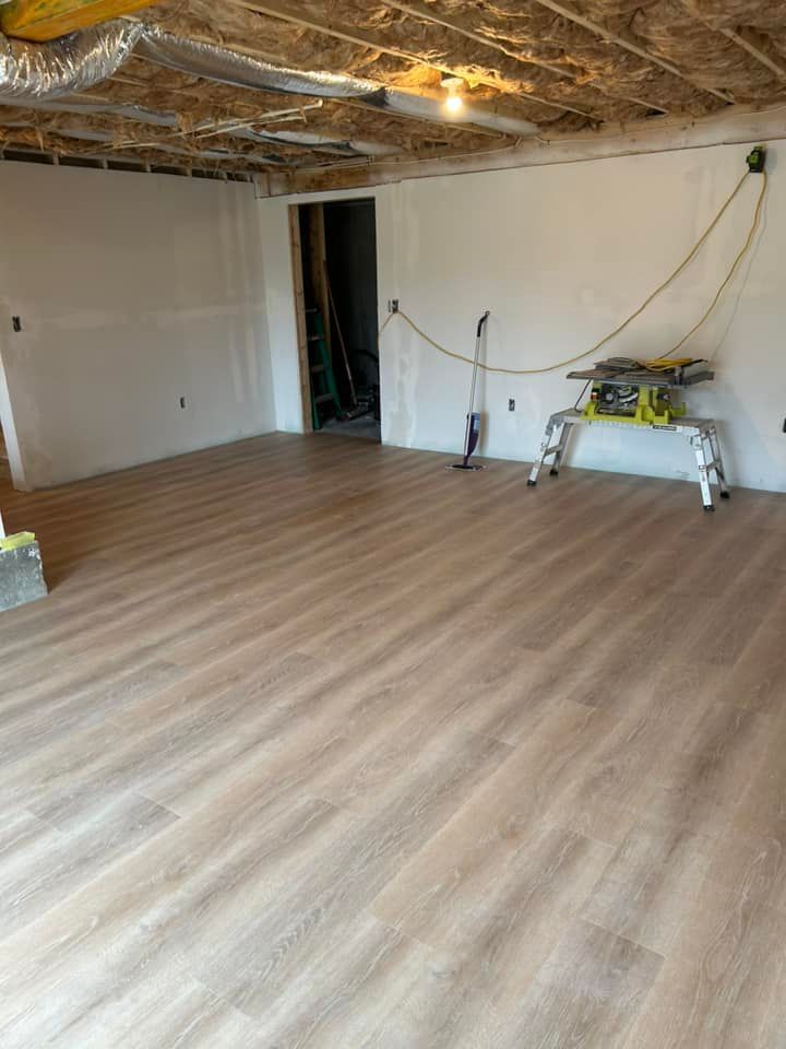 A room with a wooden floor and a table saw in it.