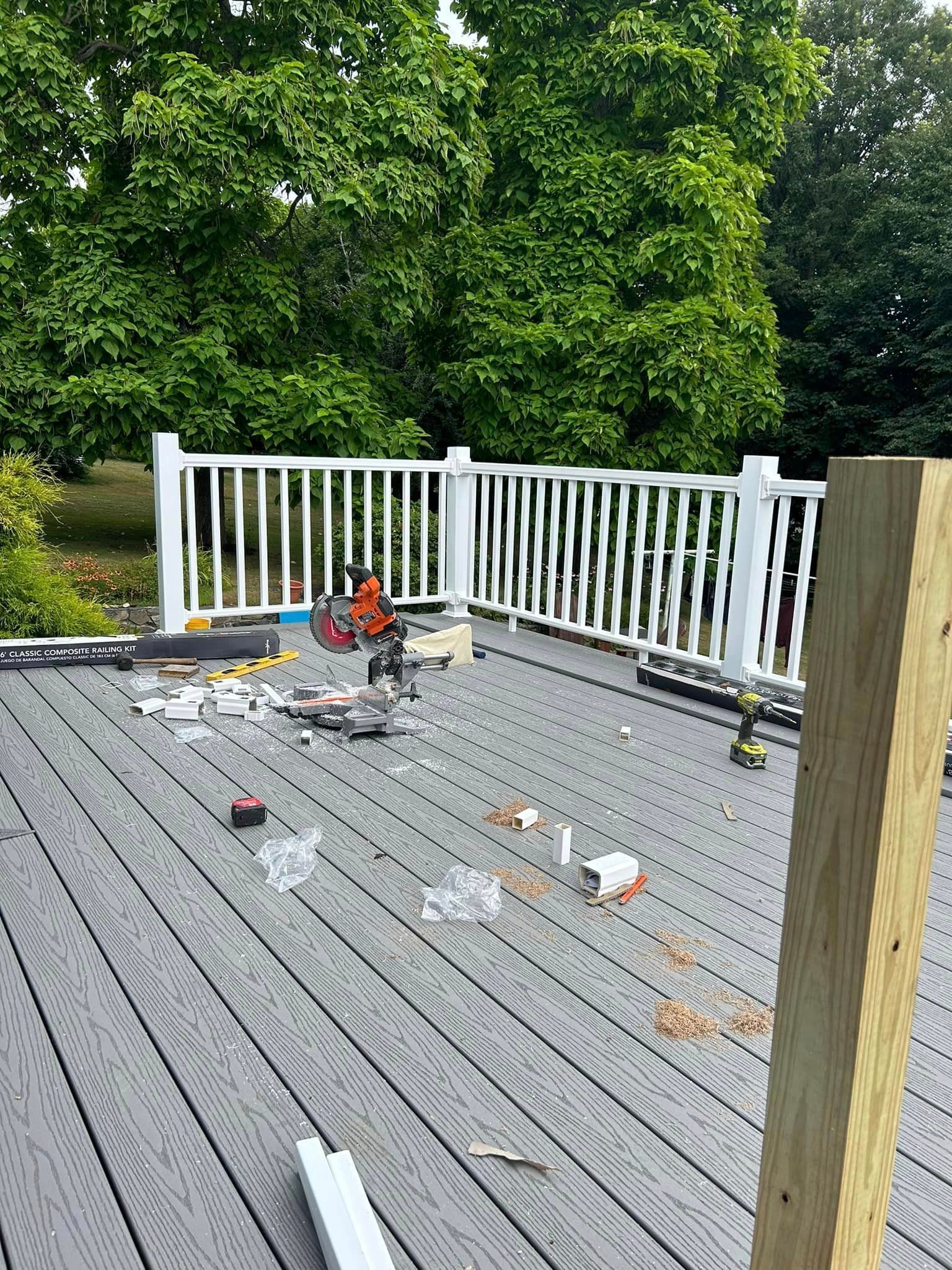 A wooden deck with a white railing is being built.