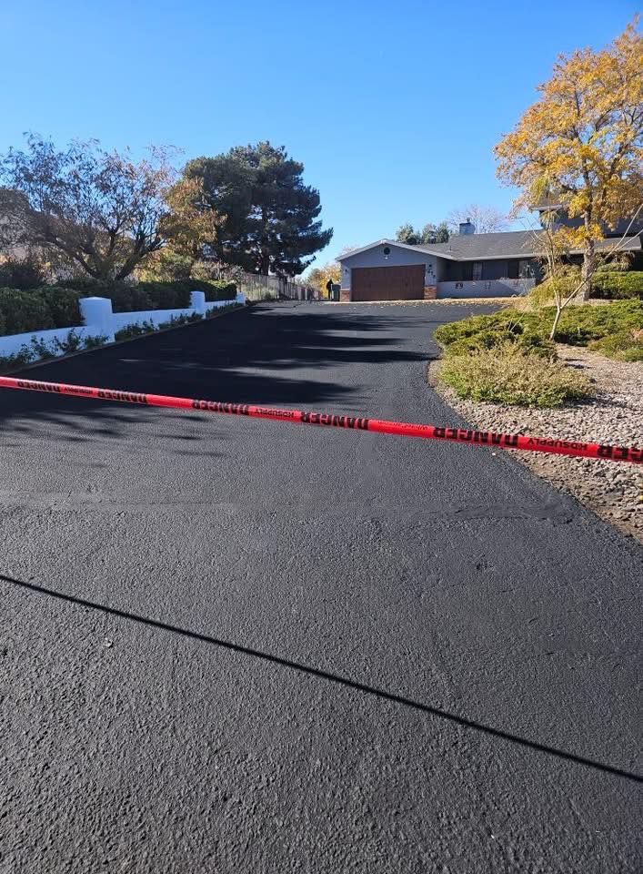 Driveway blocked by red caution tape leading to a house on a sunny day