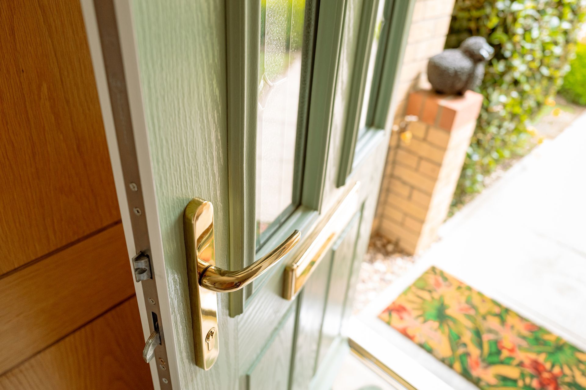 Hands in gloves adjusting a glass door handle lock with a screwdriver.