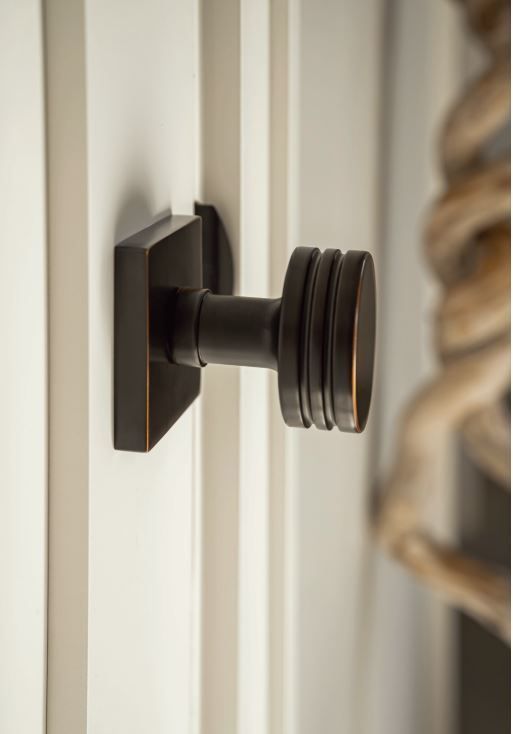 Bronze door handle on a white panel door; detail shot.