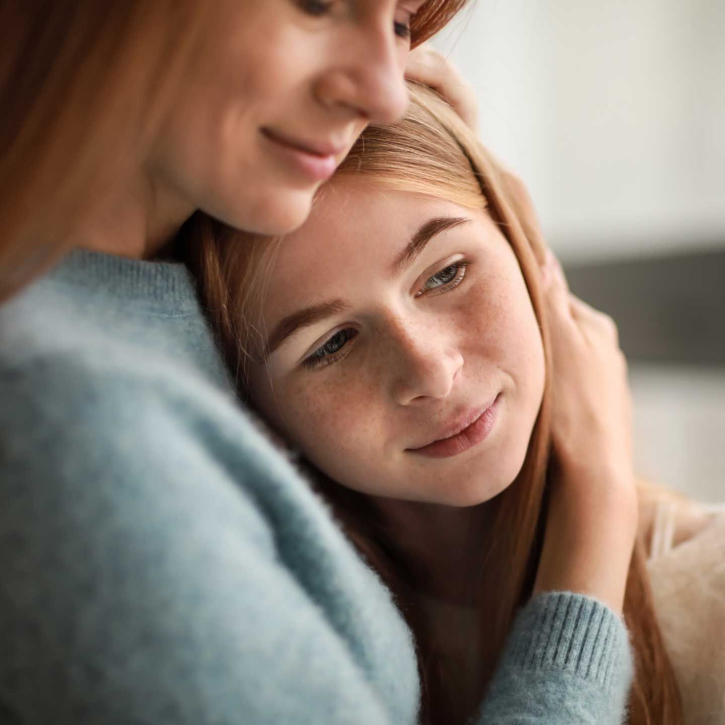 Woman comforting a person with hand on their head. Both have fair skin and reddish hair. Woman comforting a person with hand on their head. Both have fair skin and reddish hair.