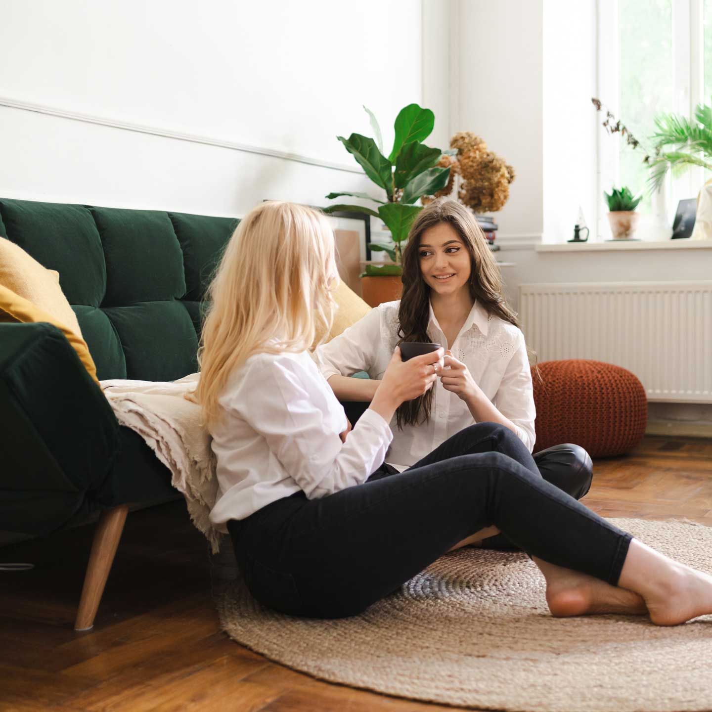 Woman comforting a person with hand on their head. Both have fair skin and reddish hair.