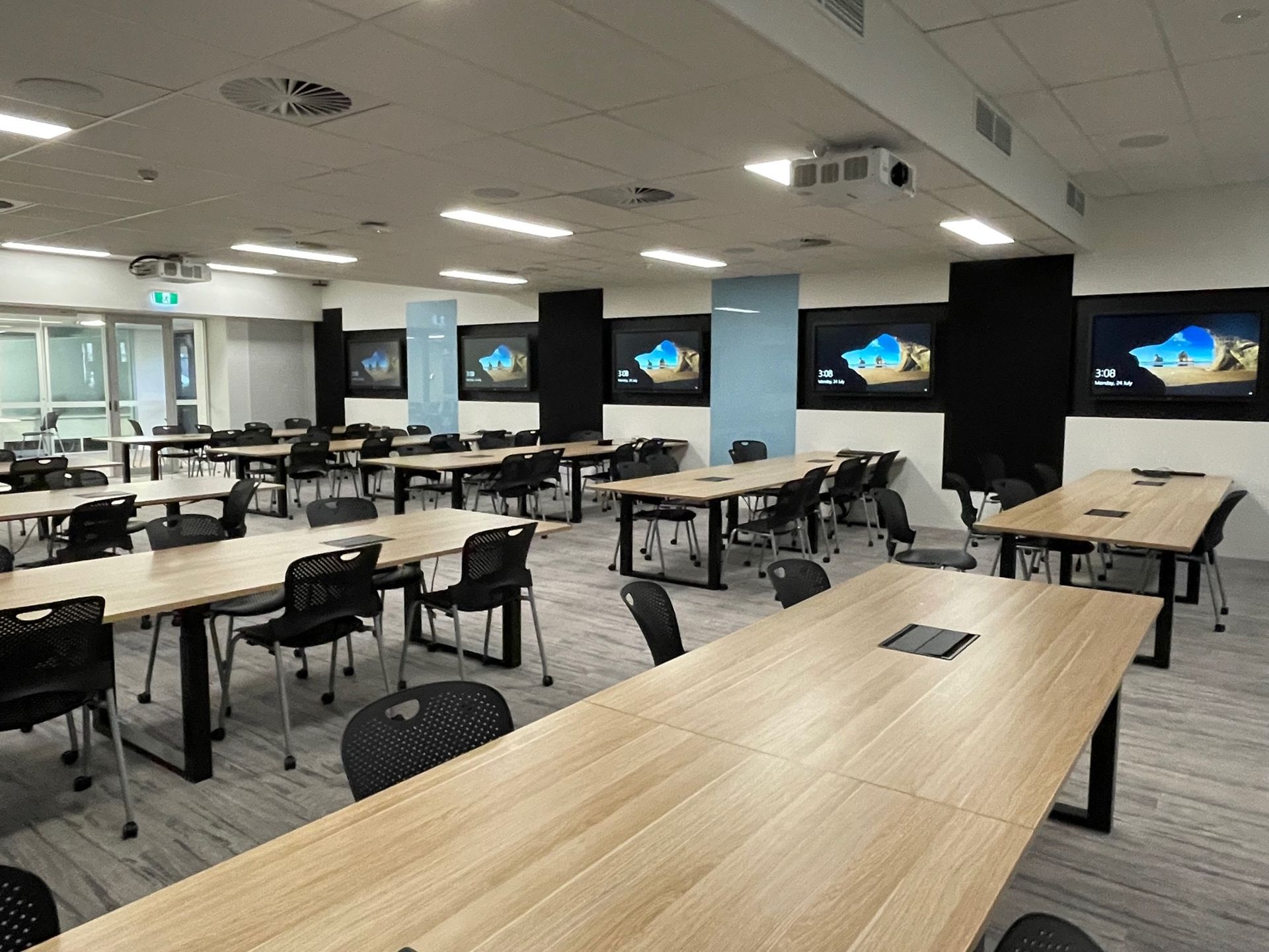 Image of training centre room with desks, chairs and television screens