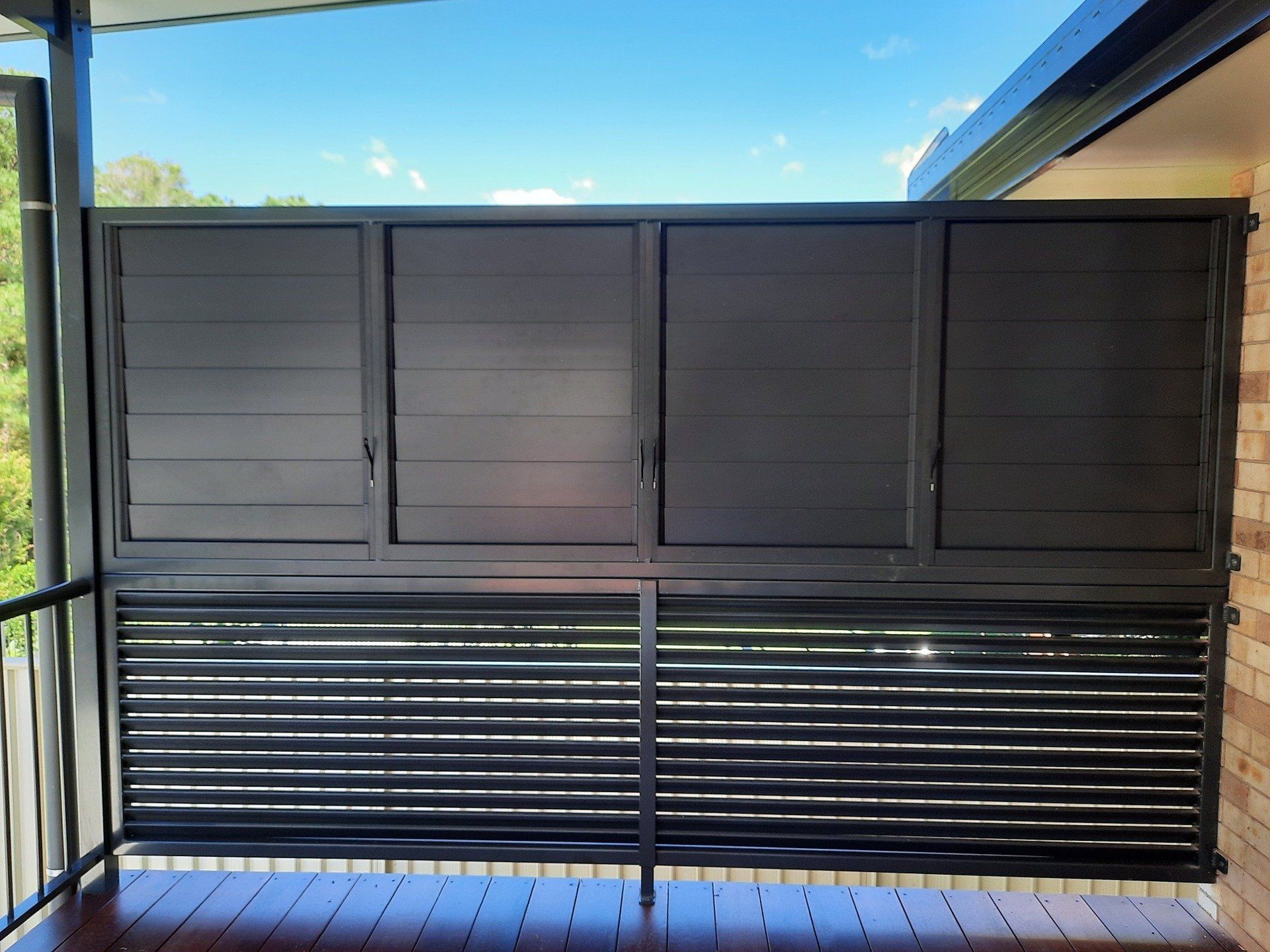 A Balcony With A Black Fence And Shutters On It — Boambee Home Improvements in Coffs Harbour, NSW