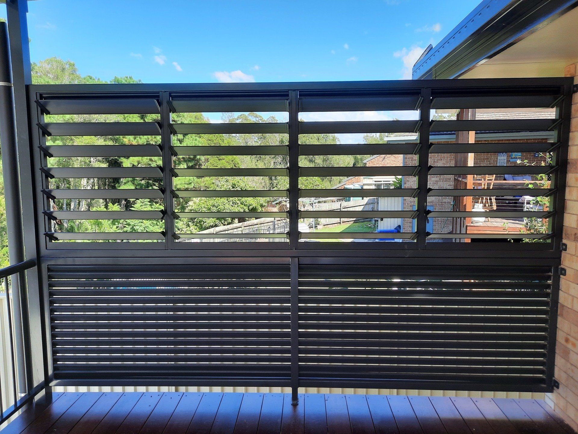 A Balcony With A Black Fence And Shutters On It — Boambee Home Improvements in Coffs Harbour, NSW