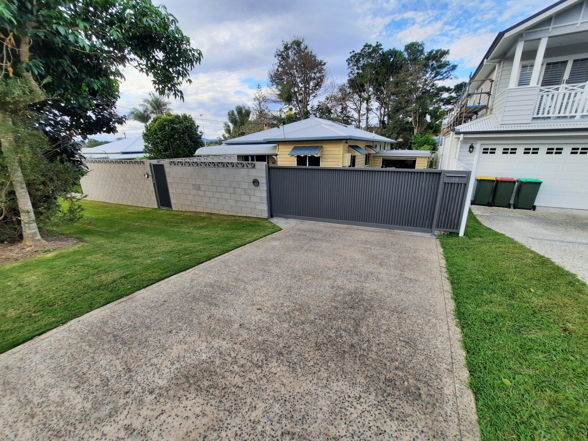 A Driveway Leading To A House With A Sliding Gate — Boambee Home Improvements in Coffs Harbour, NSW