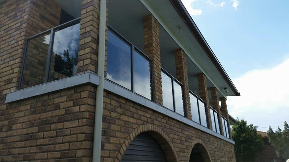 A Large Brick Building With A Balcony And A Garage — Boambee Home Improvements in Macksville, NSW