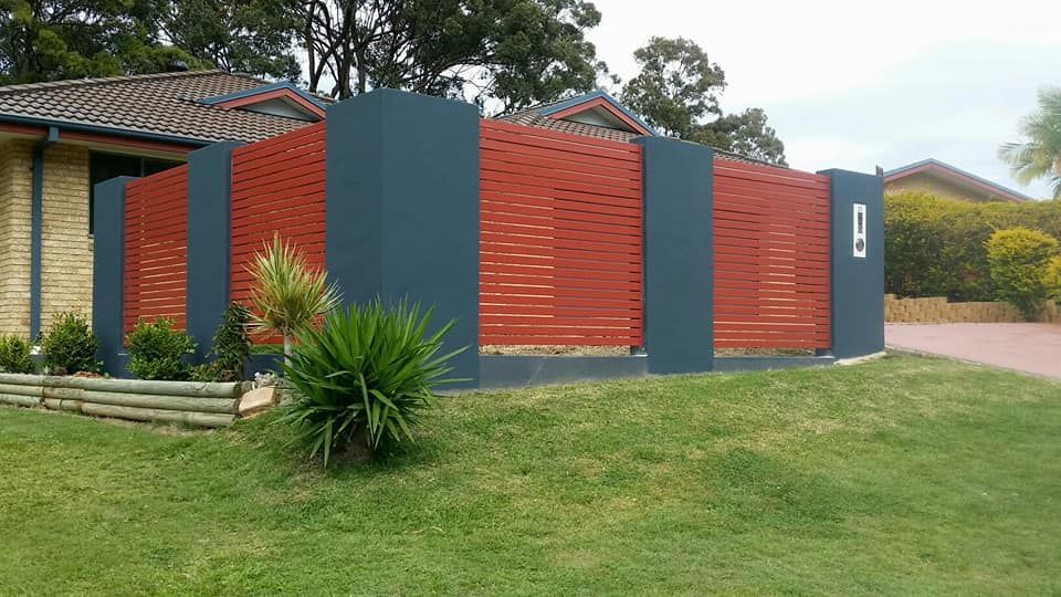 A House With A Red And Blue Fence In Front Of It — Boambee Home Improvements in Coffs Harbour, NSW