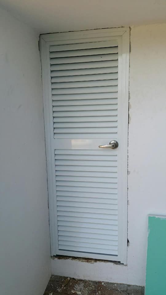 A White Door With Shutters On It Is Sitting On A White Wall — Boambee Home Improvements in Sawtell, NSW