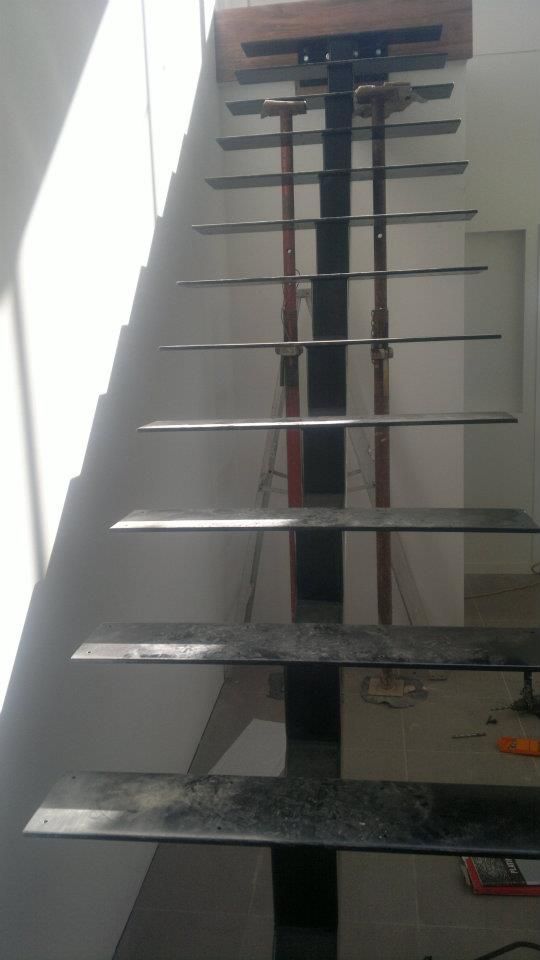 A Metal Staircase Is Being Built In A House — Boambee Home Improvements in Coffs Harbour, NSW