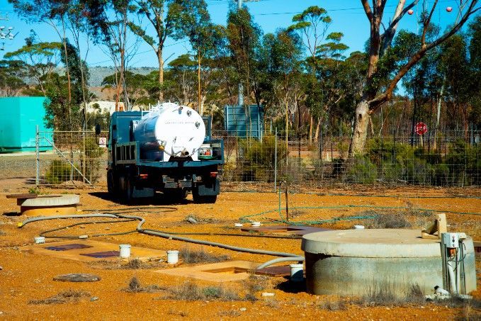 A Tanker Truck is Parked in a Dirt Field With Trees — KYK Industries in Katherine, NT