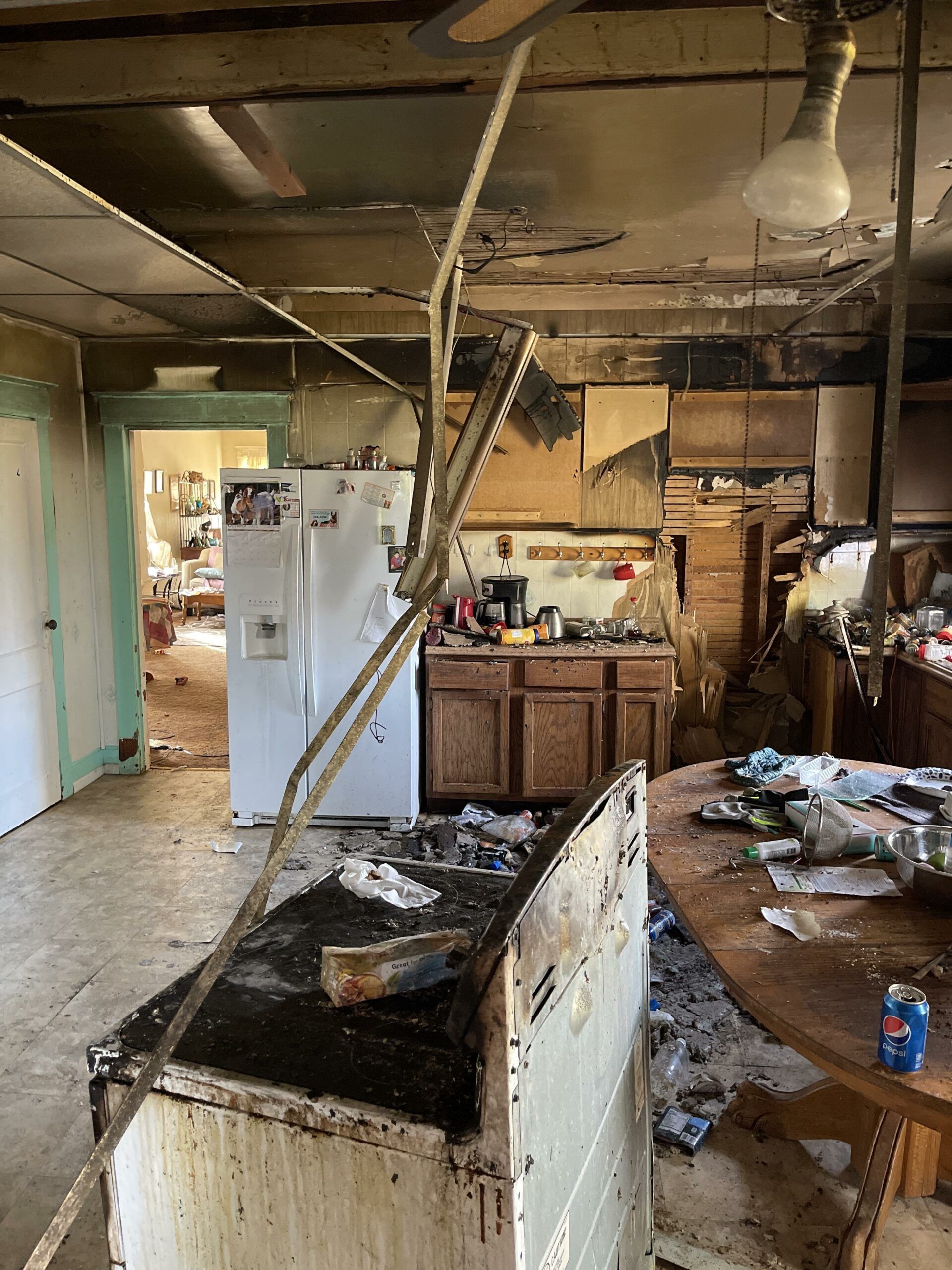 A kitchen with a stove , refrigerator , and table.
