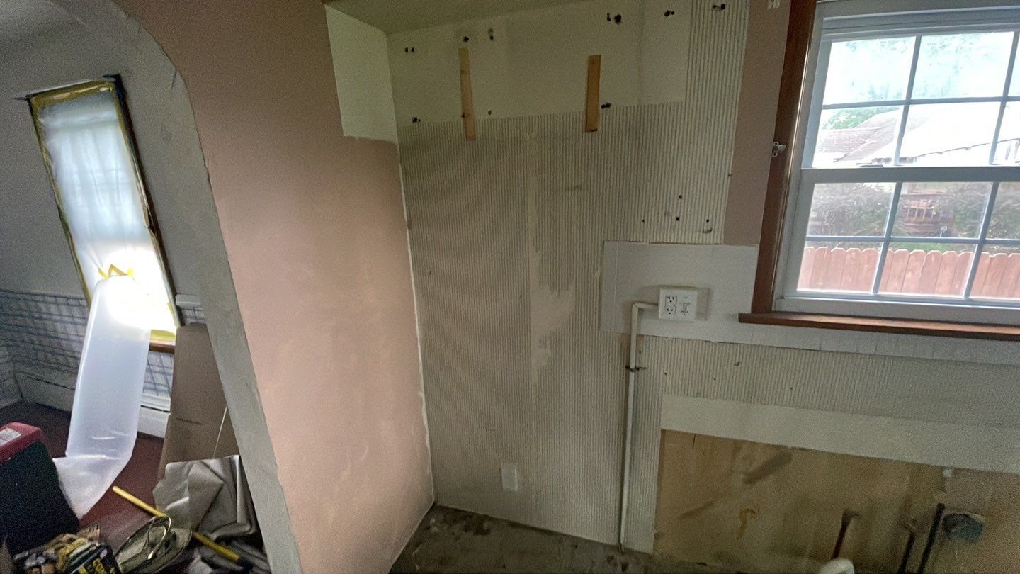 A room with a window and a wall that is being remodeled.