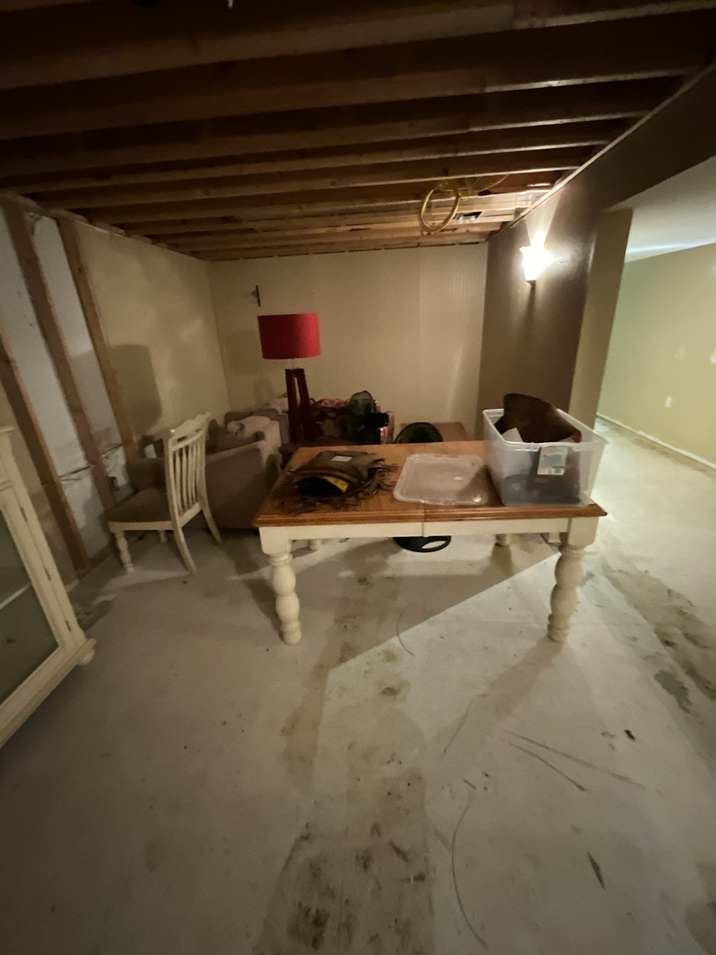 A living room with a table , chairs , and a lamp.