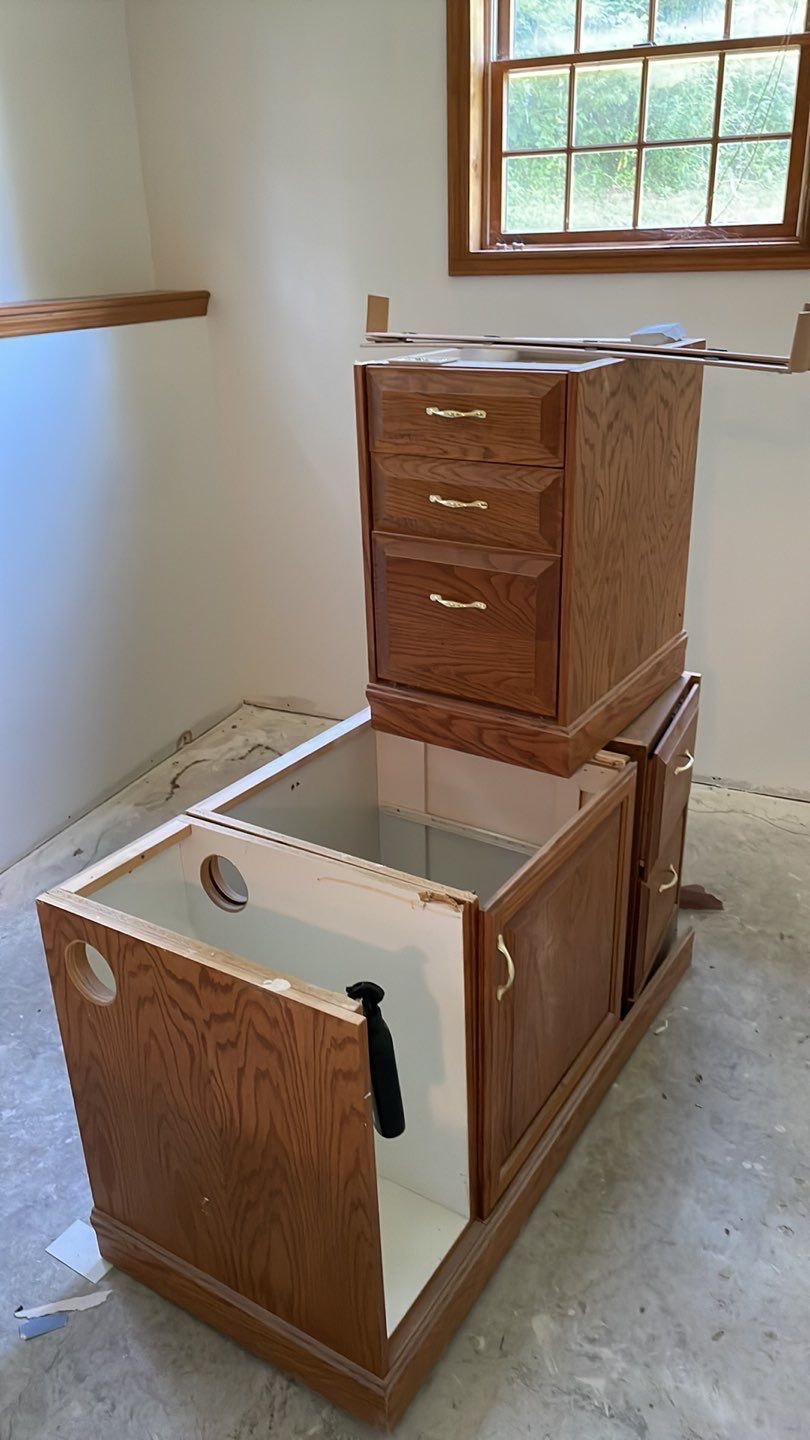 A wooden cabinet is sitting in a room next to a window.