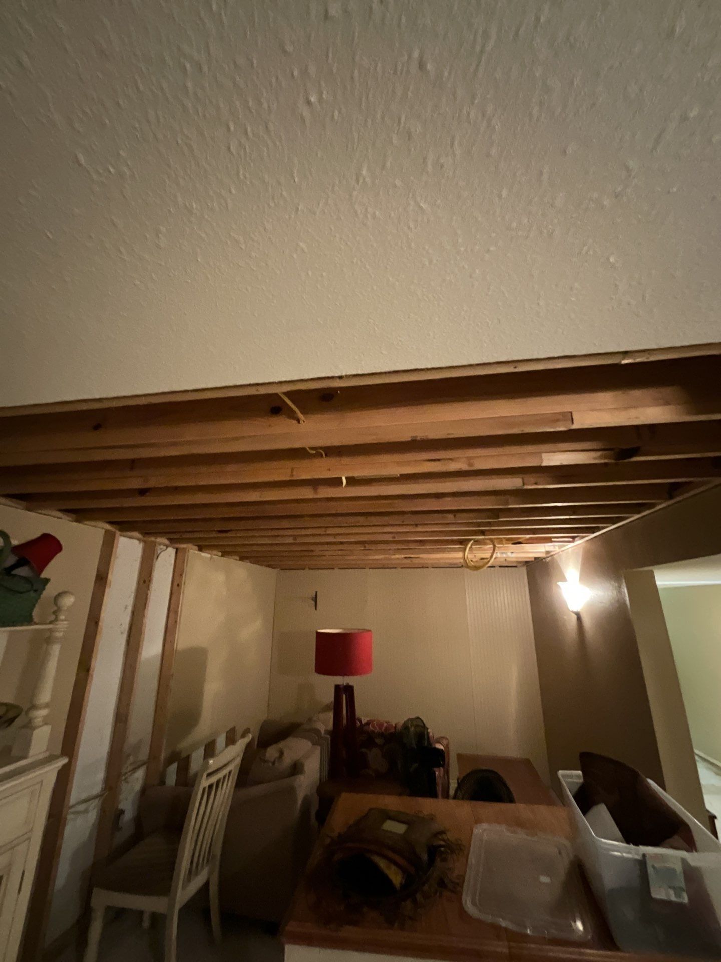 A living room with a wooden ceiling and a table and chairs.