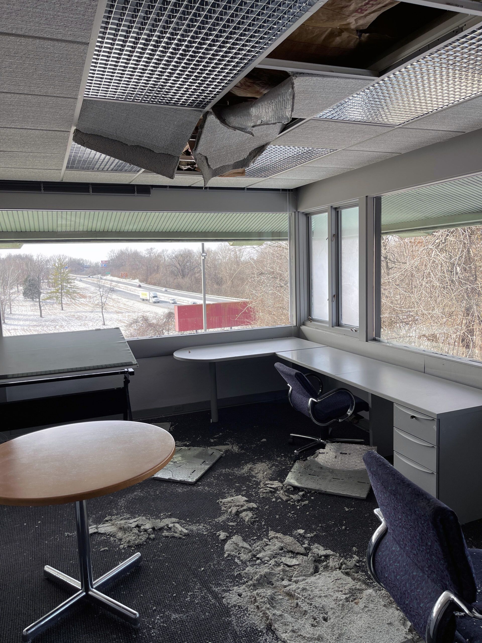 A room with a table and chairs and a ceiling that is missing