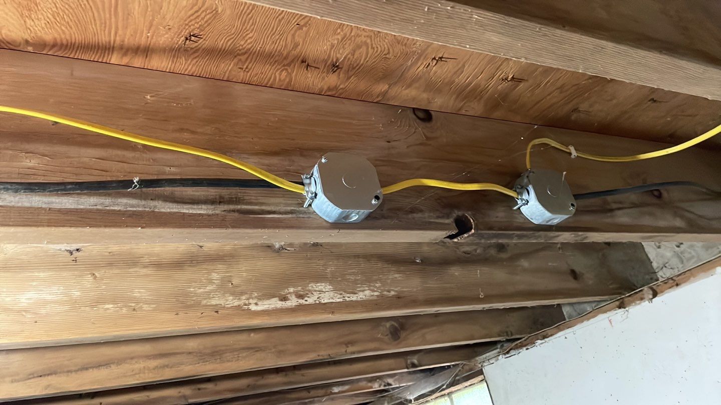 A close up of a wooden ceiling with wires coming out of it.