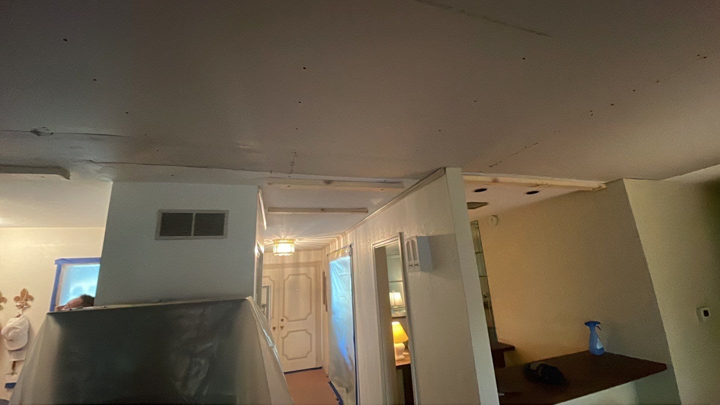 A room with a ceiling that is missing a piece of drywall.