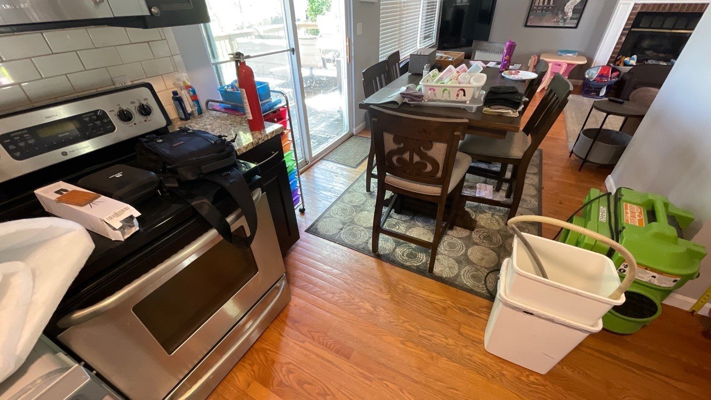 A kitchen with a stove , oven , table and chairs.