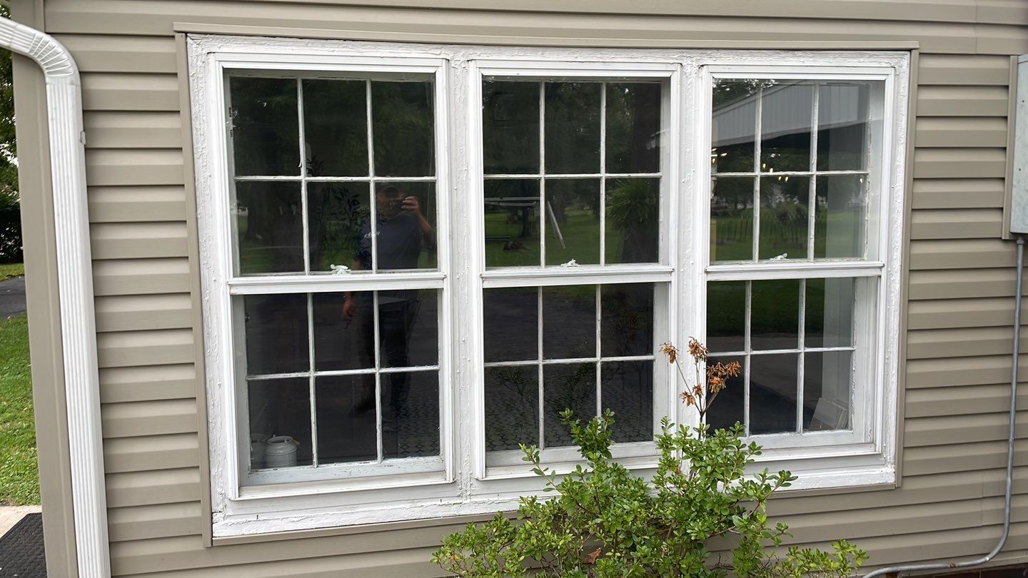 A house with a white window on the side of it.