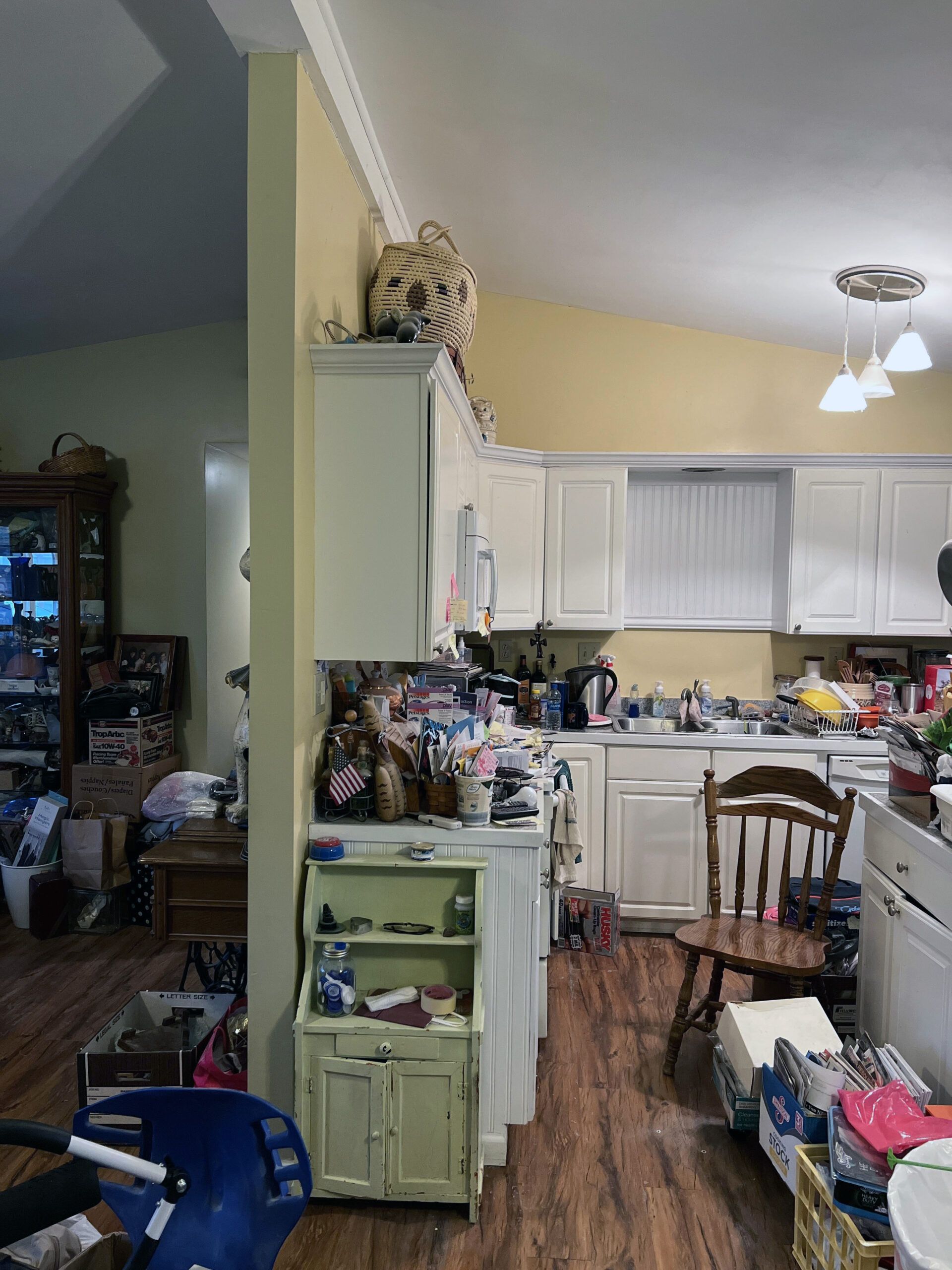 A kitchen with a lot of junk on the counters and floors.