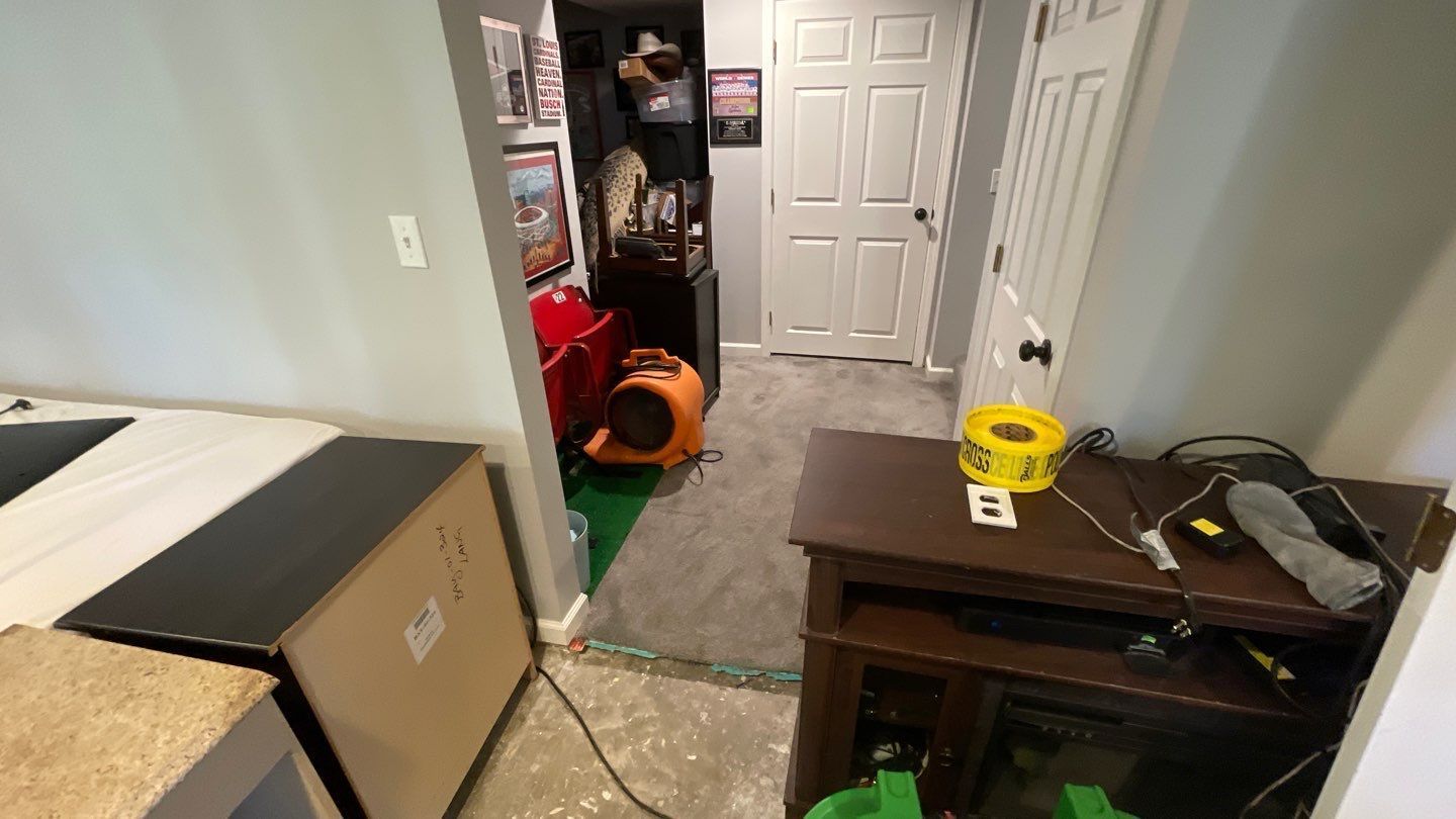 A room with a table and a fan in it.