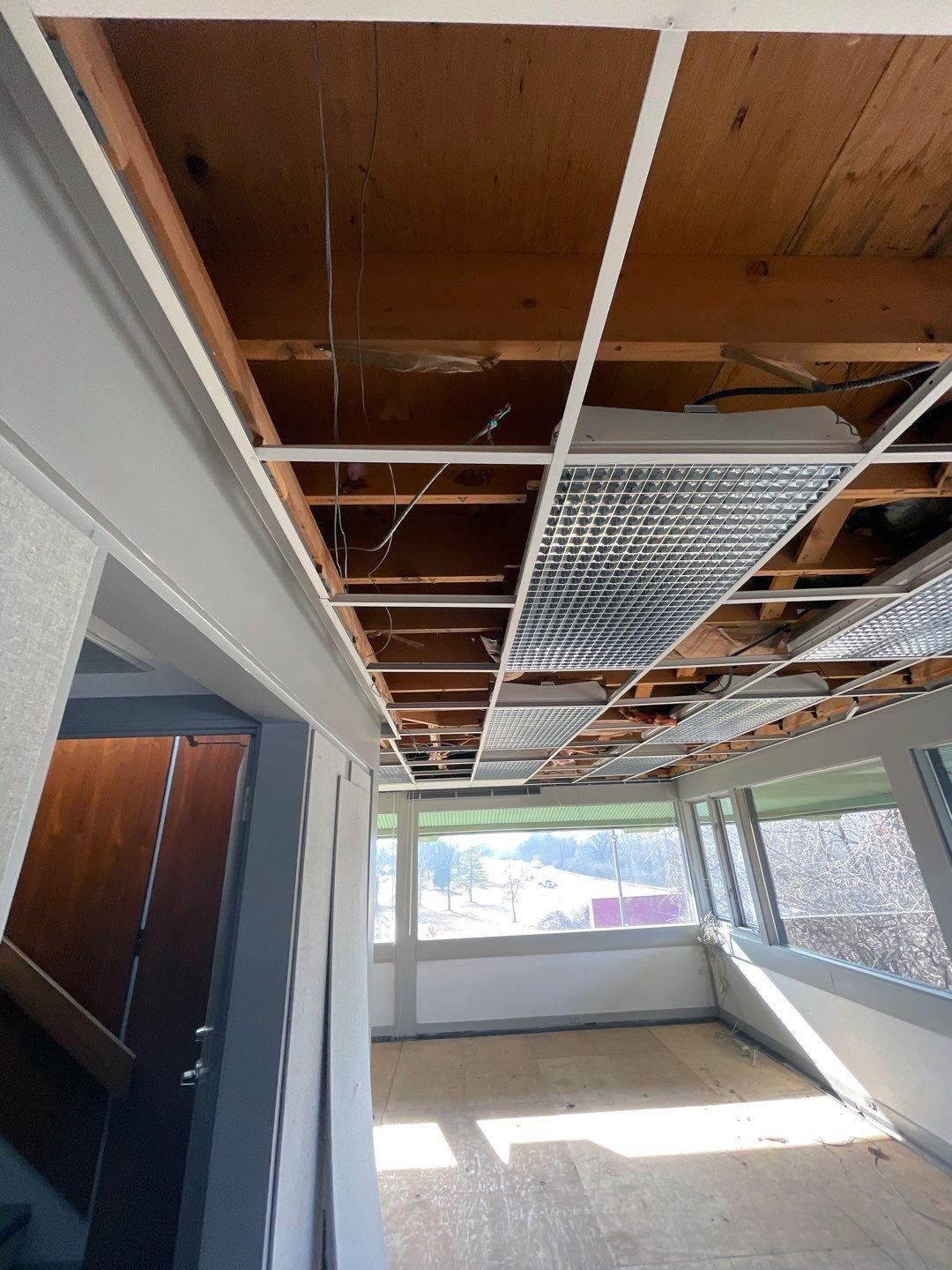 A room with a ceiling that is missing and a staircase in the background.