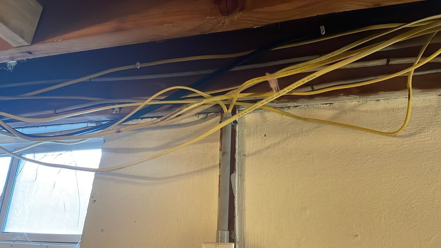A bunch of wires are hanging from the ceiling of a building.