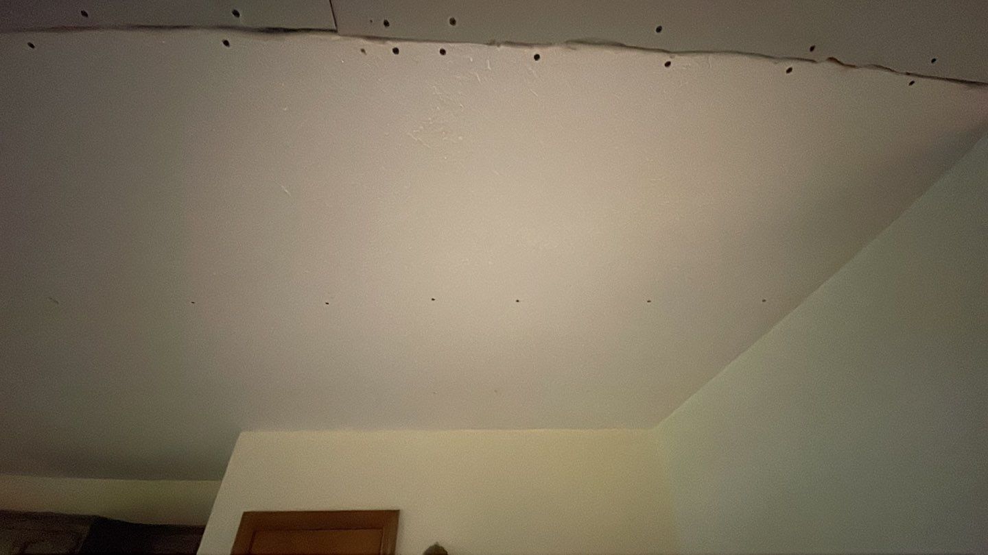 A room with a white ceiling and a wooden door.