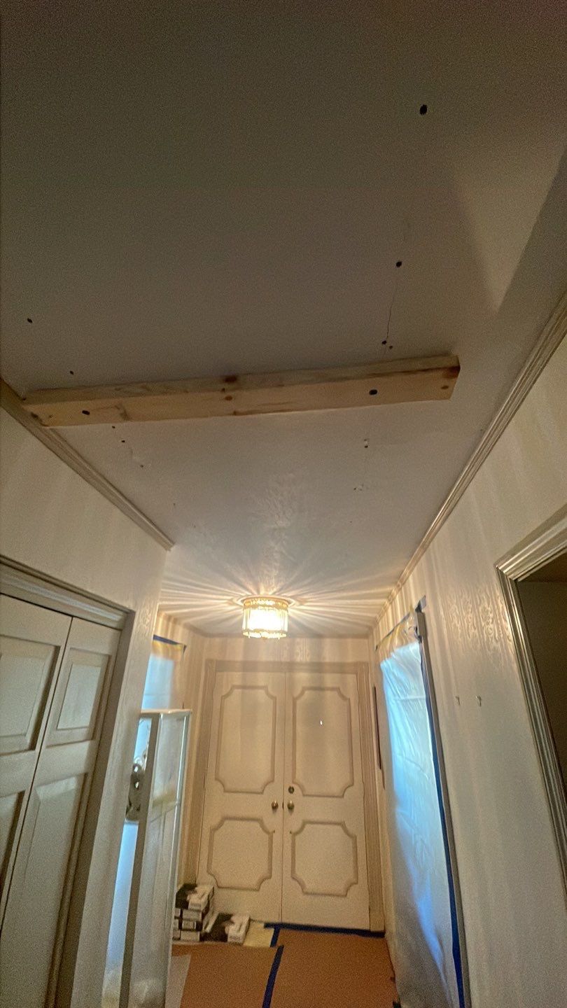 A hallway with a wooden beam hanging from the ceiling.