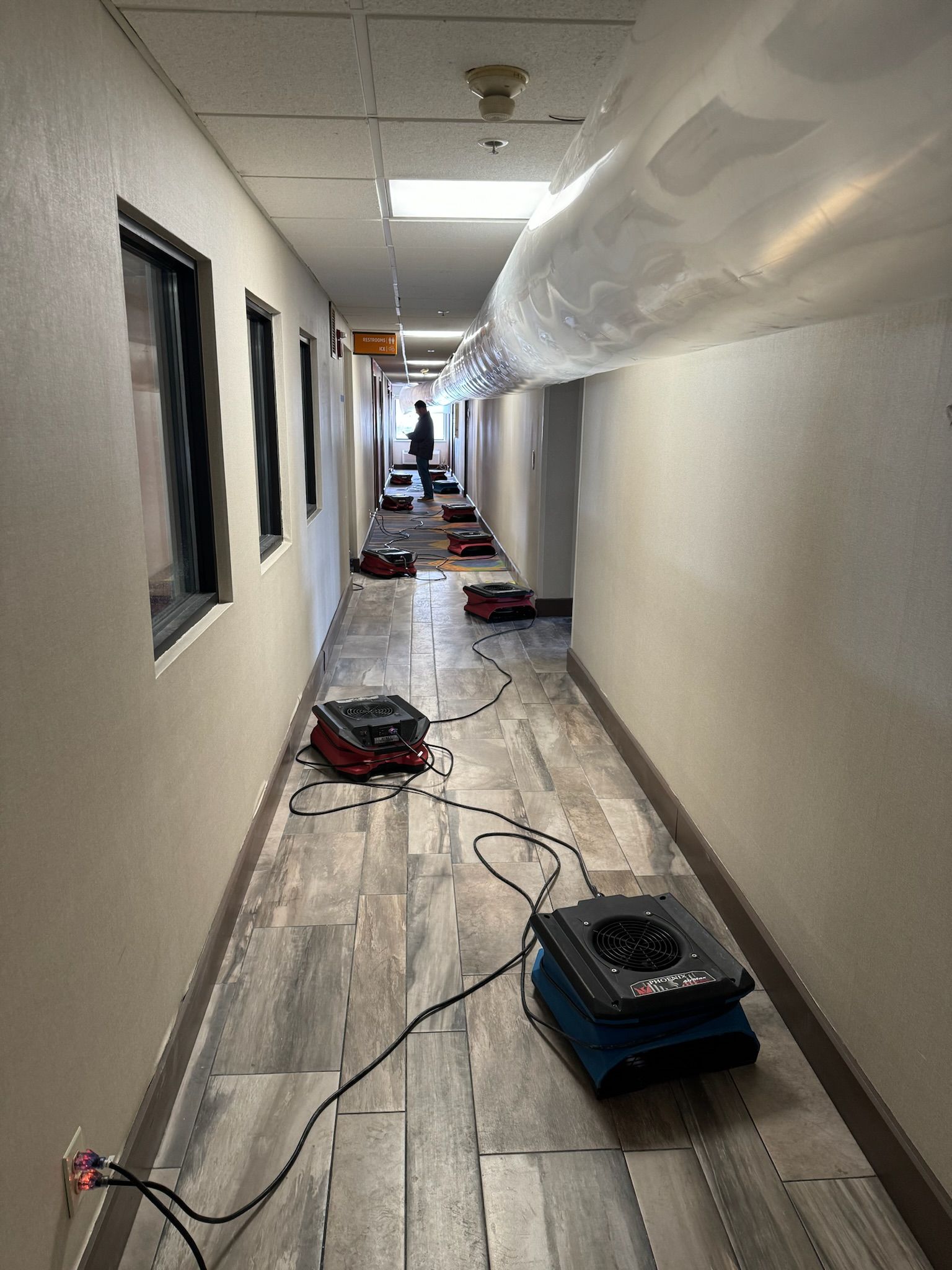A long hallway with a lot of fans on the floor.