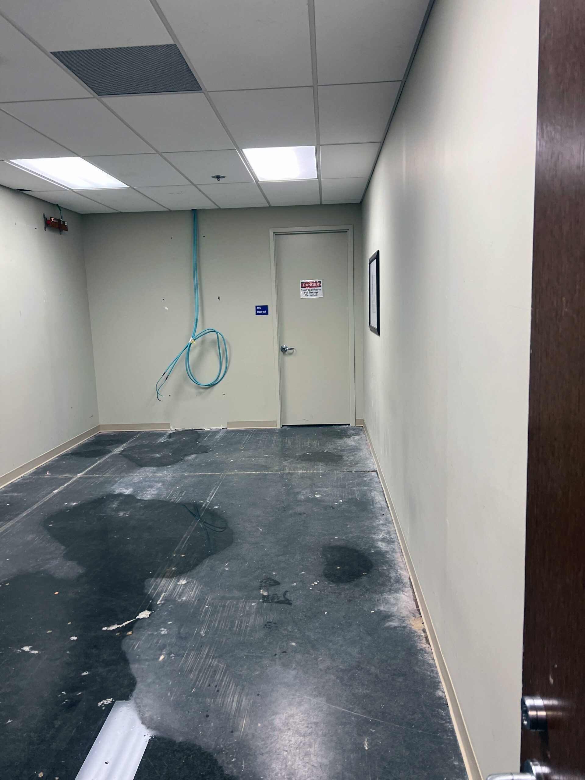 A hallway with a door and a tape measure on the wall