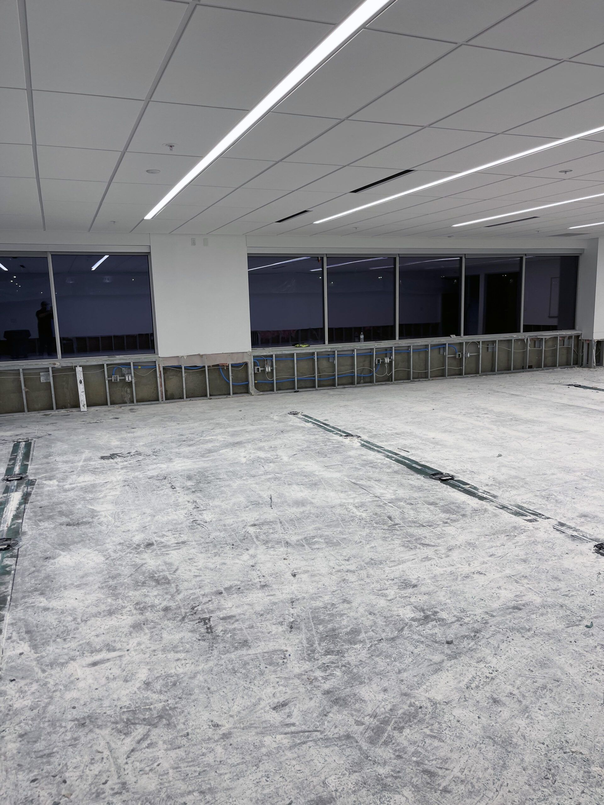 A large empty room with a lot of windows and a concrete floor.