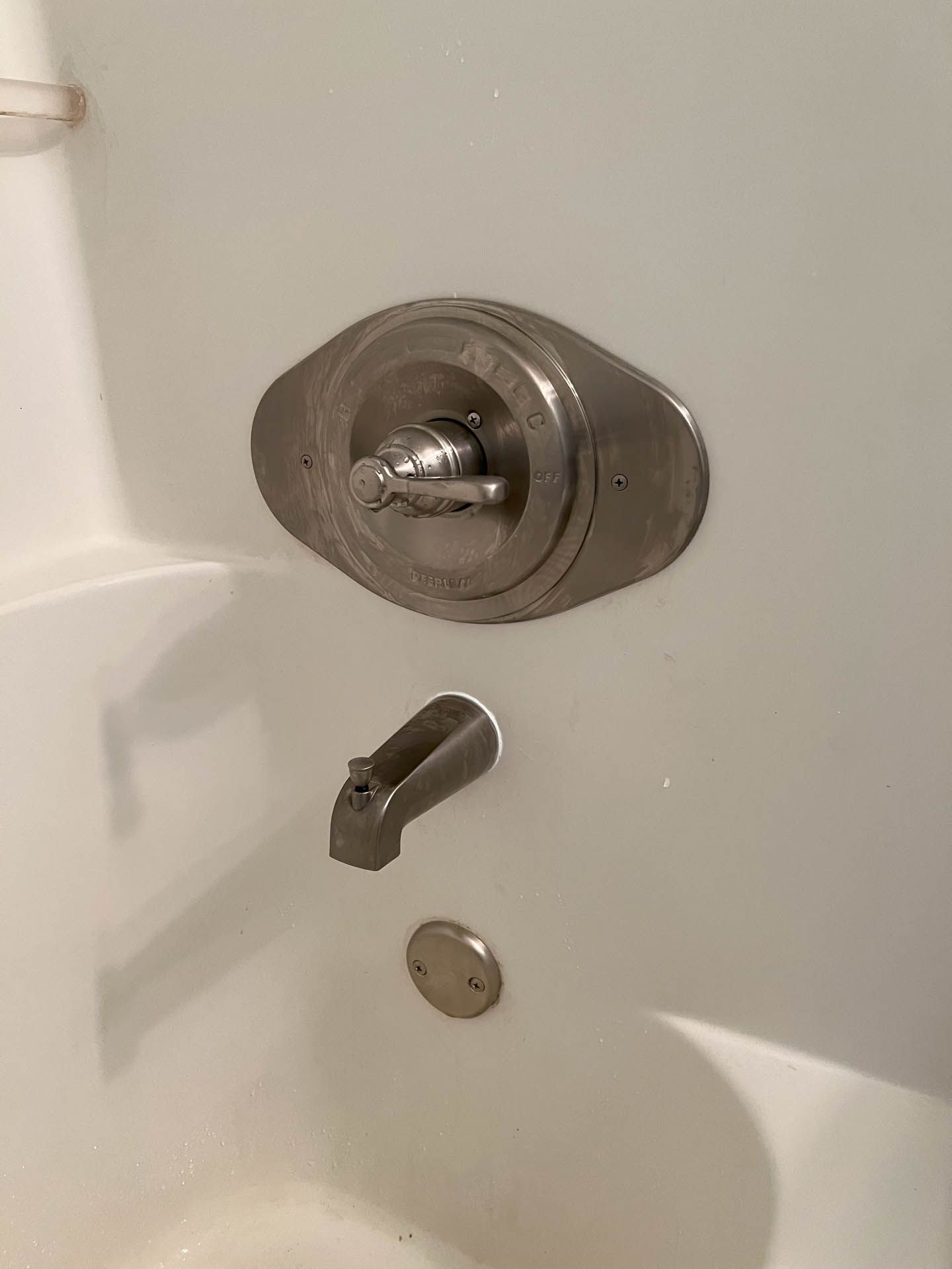A close up of a bathtub with a shower head and faucet.