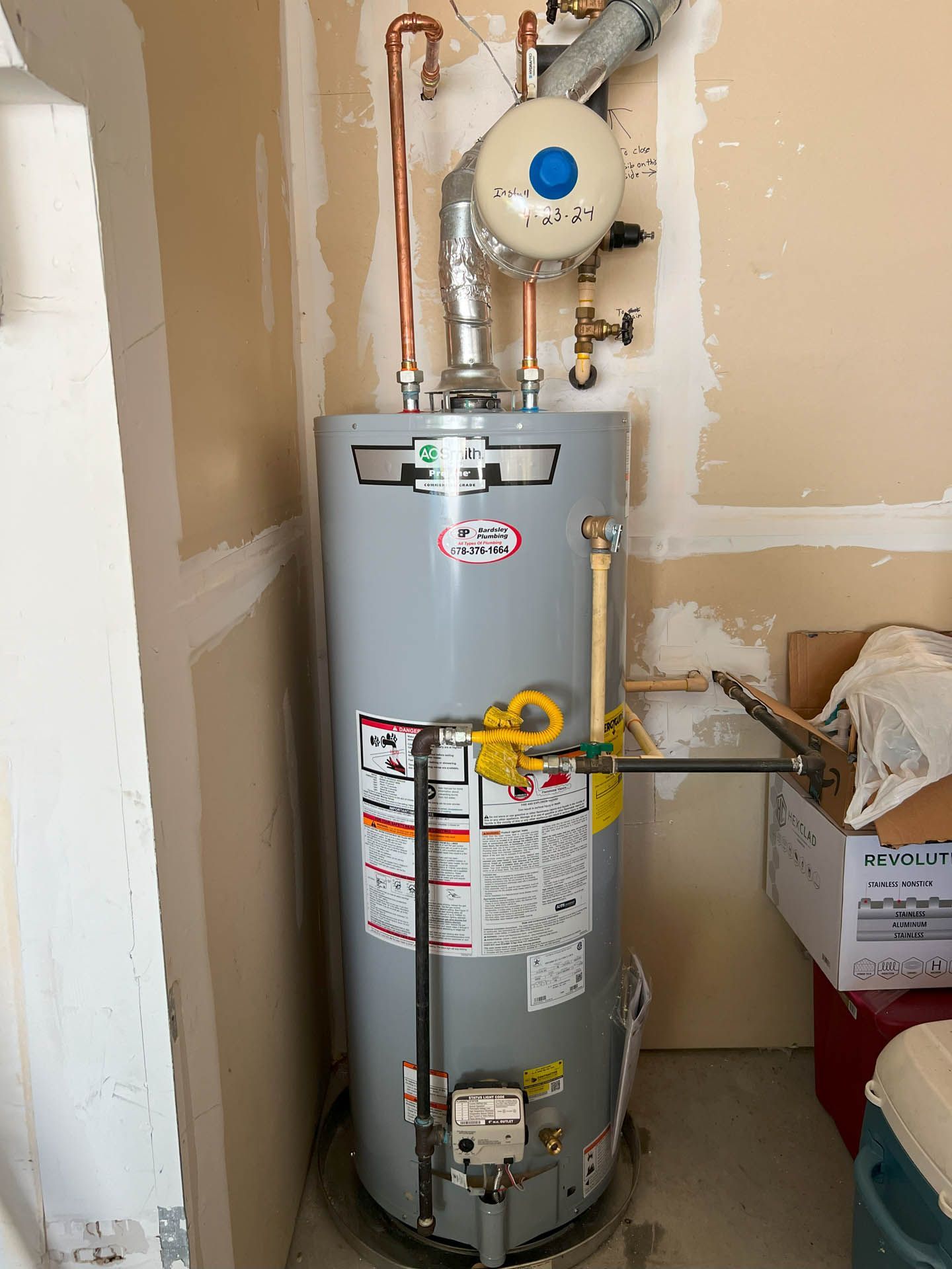 A water heater is sitting in a room next to a wall.