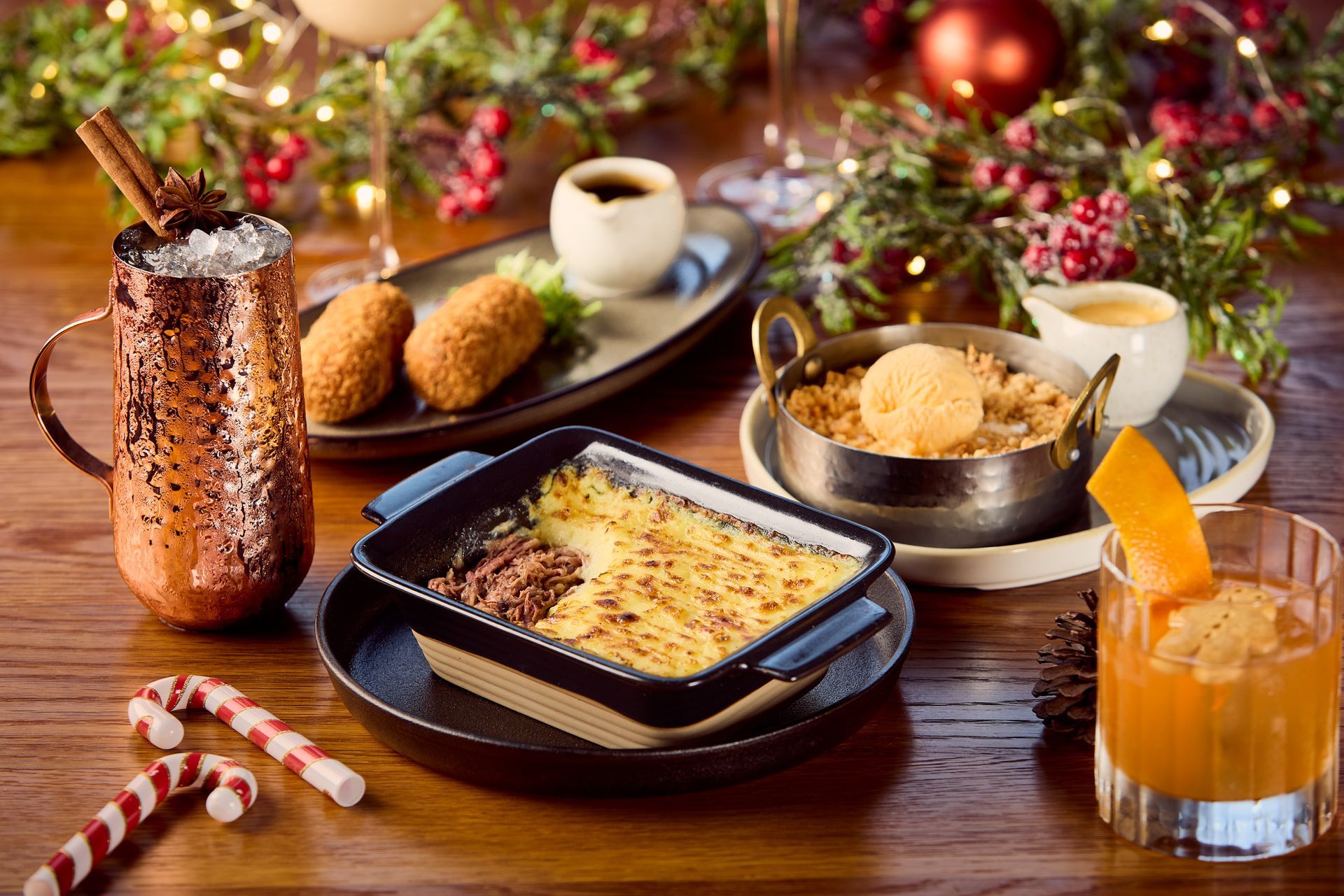 A wooden table topped with plates of food and drinks.